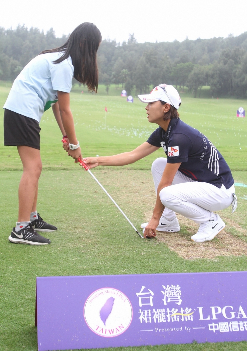 南韓球星崔羅蓮在高球教學活動中，親自指導小朋友的揮桿動作。