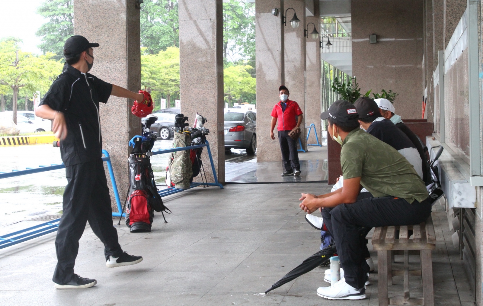 大會宣布因雨勢太大延賽選手在戶外走廊傳接棒球熱身(鍾豐榮攝影)