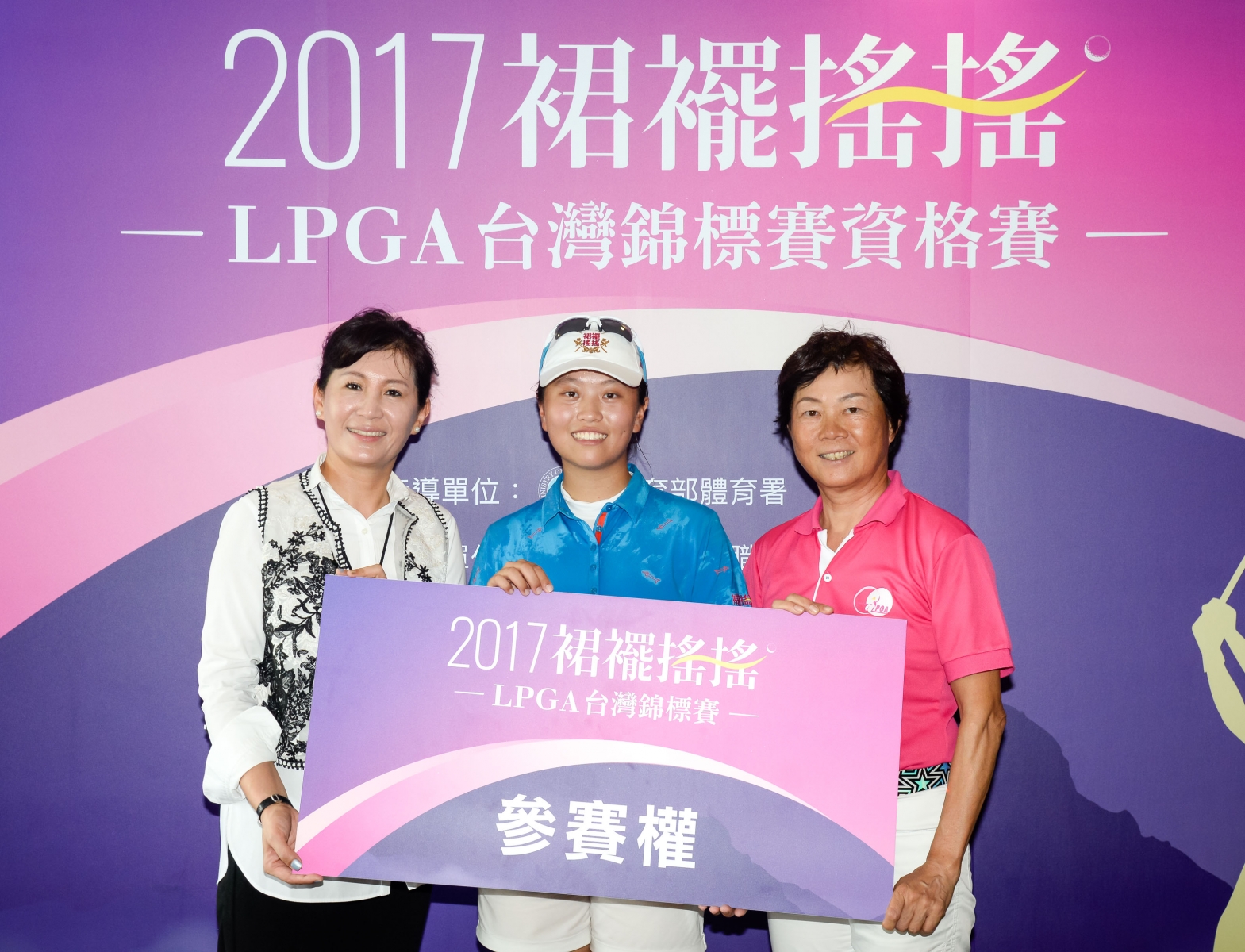 盧昕妤(中)從裙襬搖搖基金會董事張韋文(左)與女子高爾夫協會理事長鄭美琦(右)手中接下參賽資格。