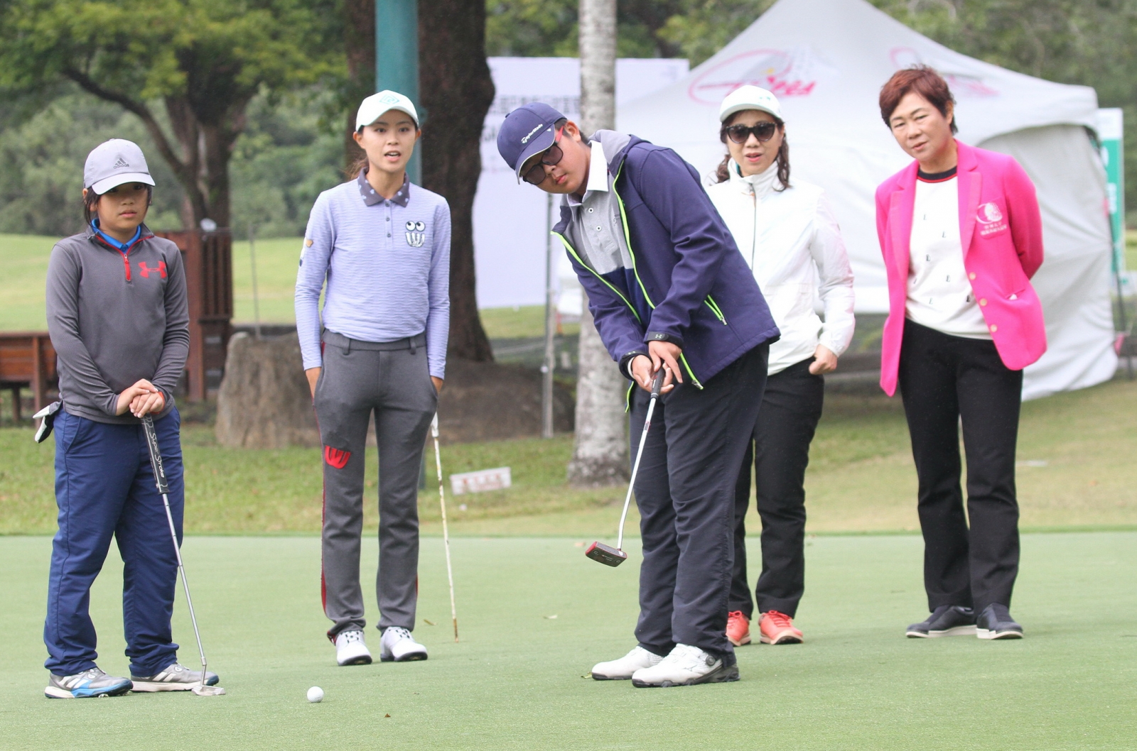 職業選手張靖翎(左二)賽後傳授推桿心法給業餘青少年選手，法國巴黎銀行財富管理執行總監謝淑琴(右二)與TLPGA理事長鄭美琦（右一）在旁觀看。