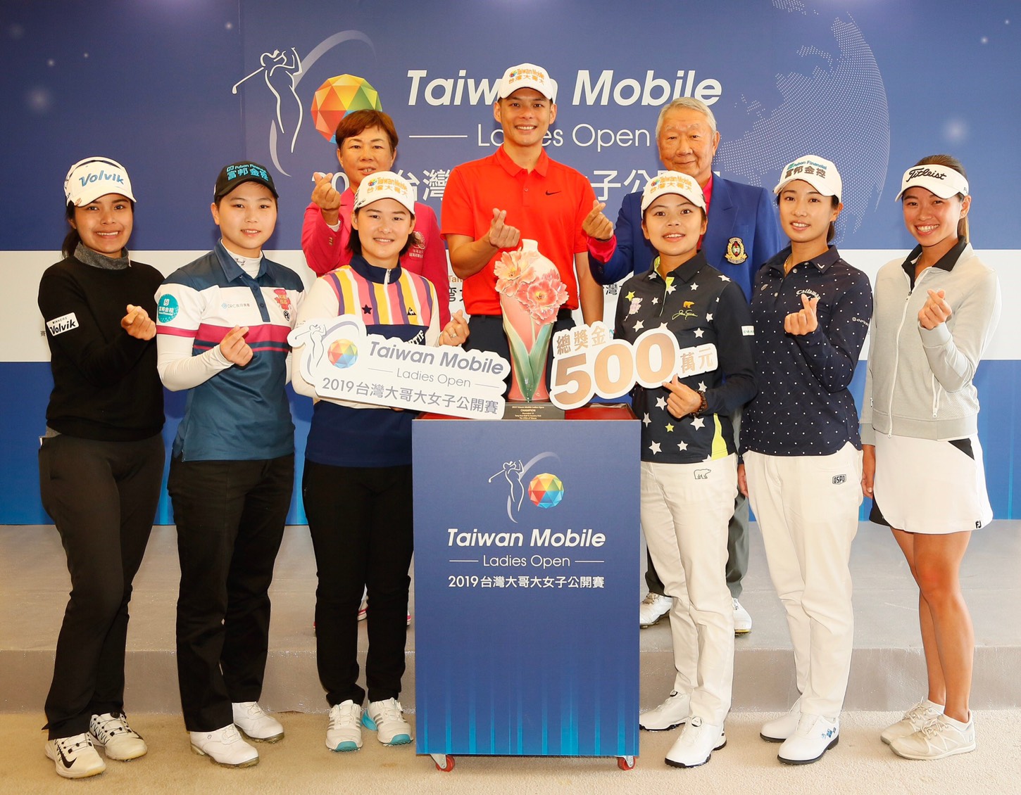 (後排左起)TLPGA理事長鄭美琦、台灣大哥大總經理林之晨與東華高爾夫俱樂部總經理張歐誠，賽前記者會與參賽明星選手共同比出手指愛心手勢