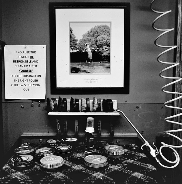 男子更衣室的擦鞋區，牆上懸掛潘‧史都華在1993年巴圖斯羅美國公開賽揮桿英姿。