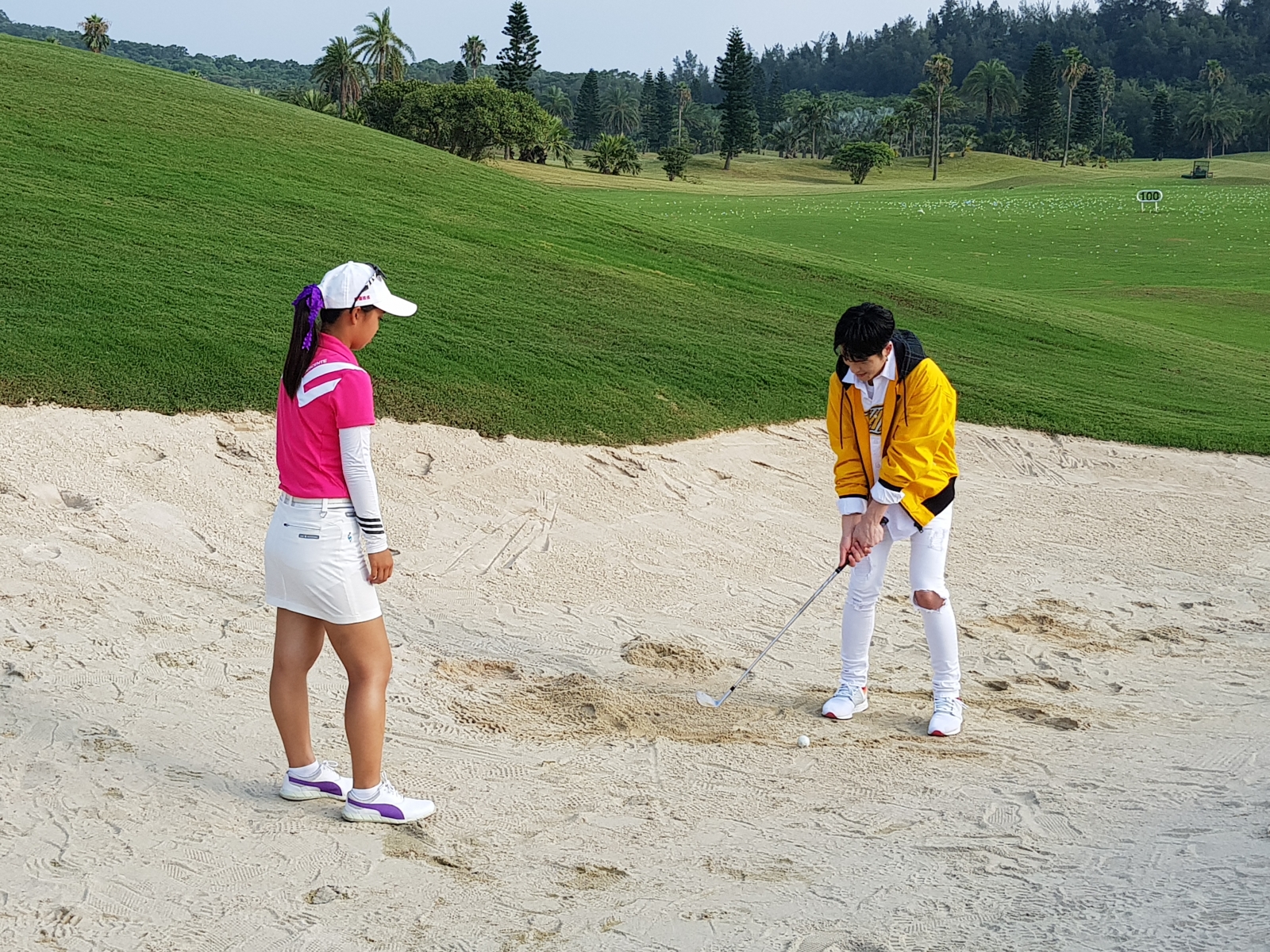 天王蕭敬騰(右)使用許淮茜(左)的沙坑桿玩了幾下，順便向她討教了幾招。
