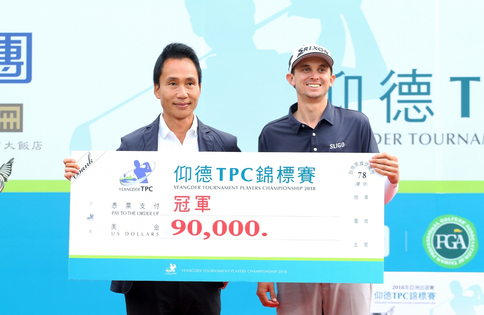仰德集團董事長許育瑞(左)頒發2018仰德TPC錦標賽冠軍支票；奪冠的美國球員卡特林(John Catlin, 右) 後來成為2024年亞巡賽獎金王，未來高爾夫生涯發展亮麗可期。